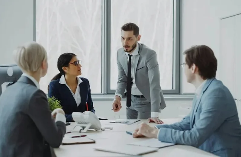 A product team talking through a plan around a meeting table